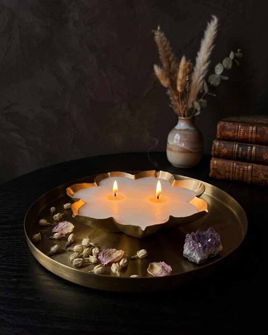 Two wicks burning in a lotus urli on a brass tray