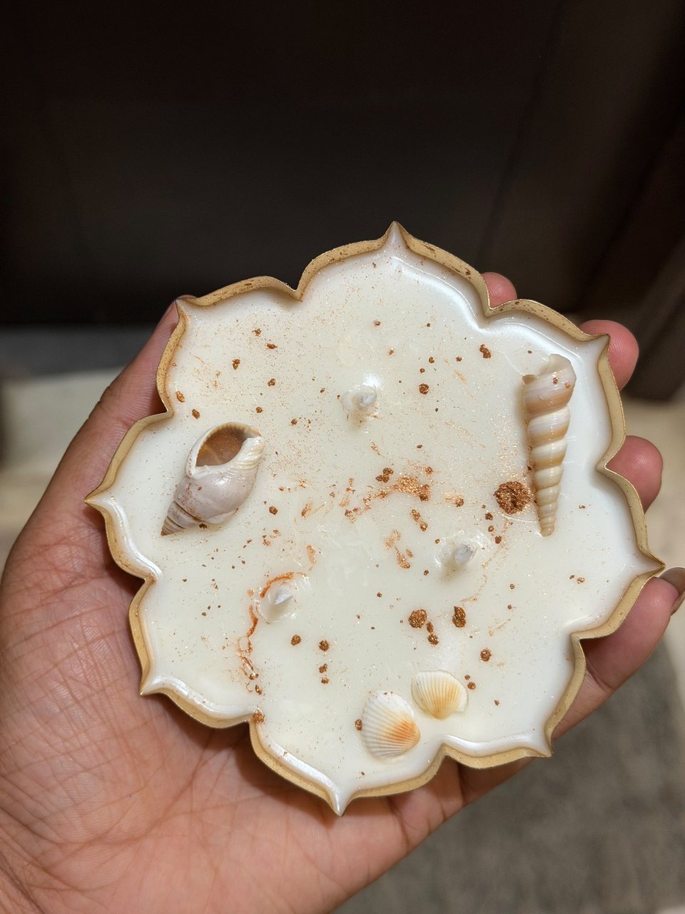 A Lotus Urli with sea shells, held in a buyer's hand
