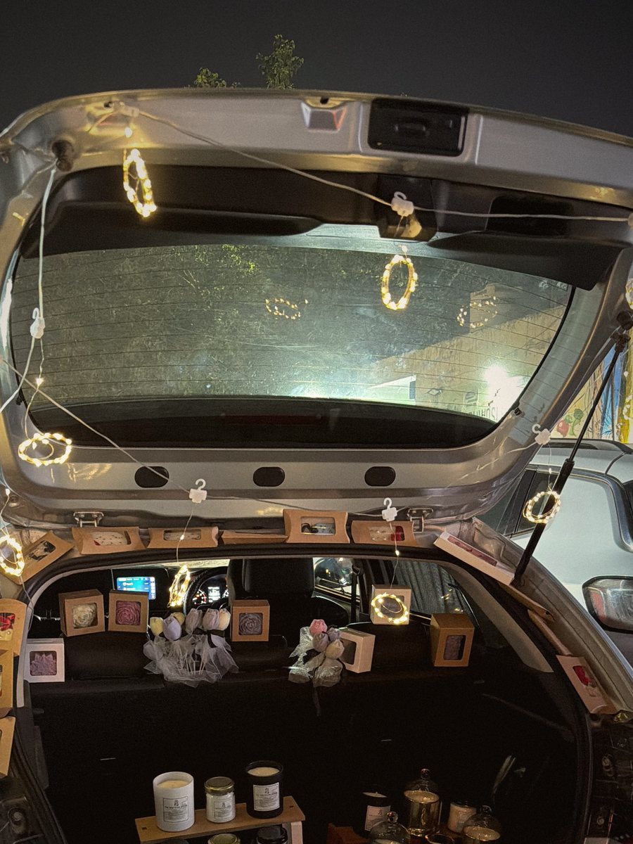 The raised boot lid strung with fairy lights against the night sky
