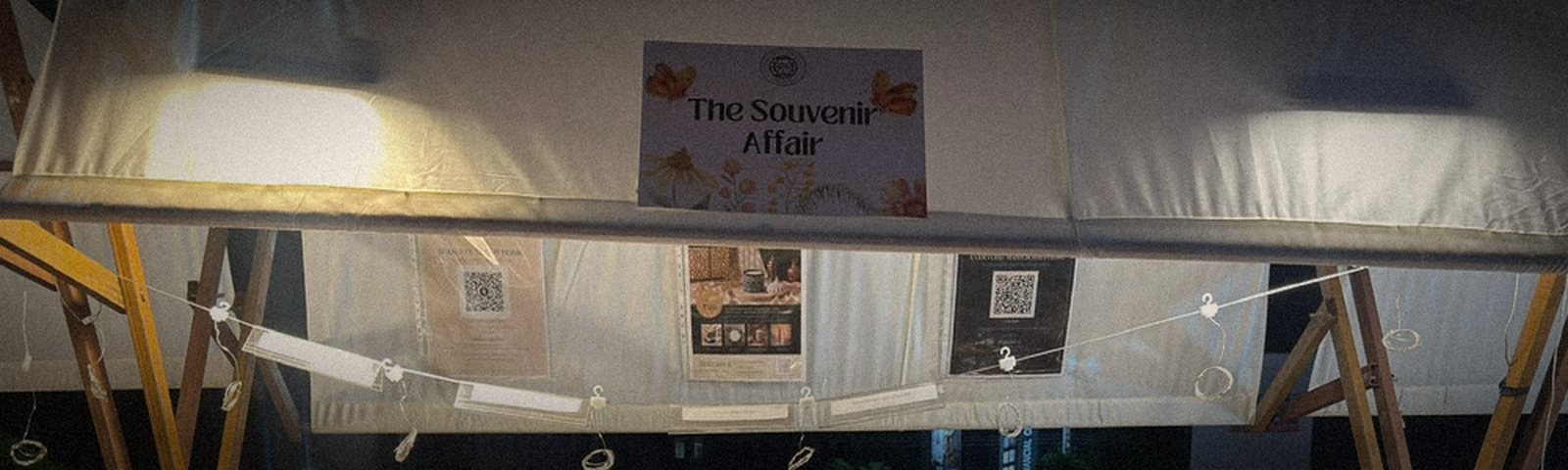 The Souvenir Affair sign hanging under the canopy, with fairy lights strung beneath it