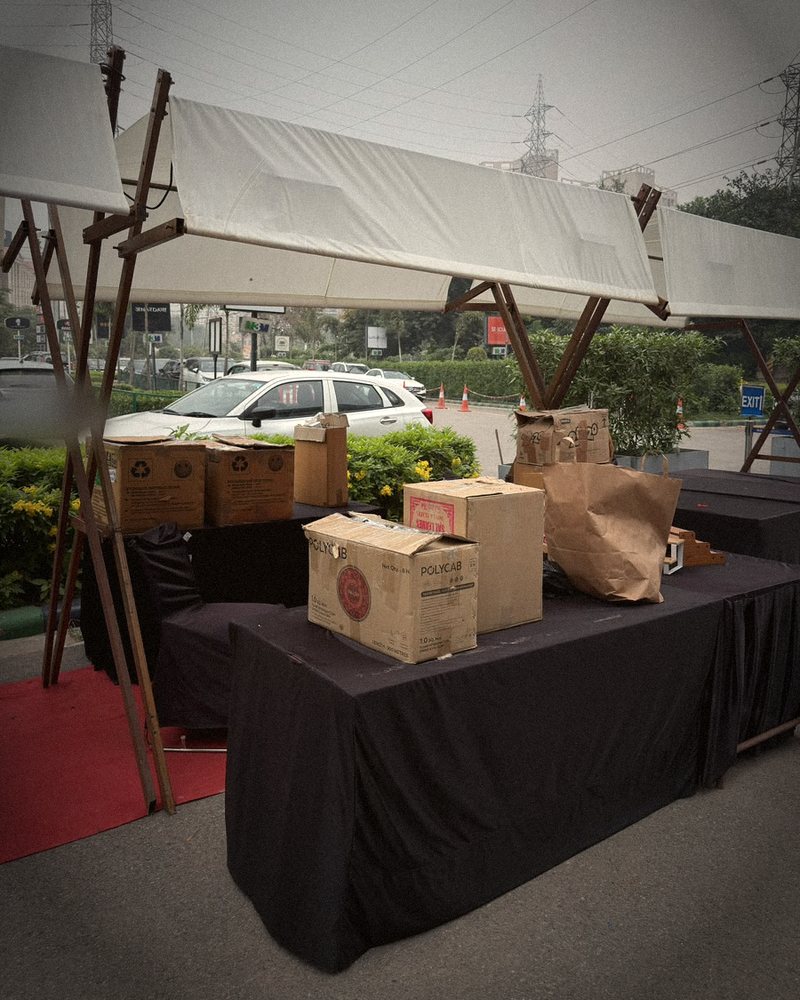 Cartons stacked on bare black tables under an empty canopy