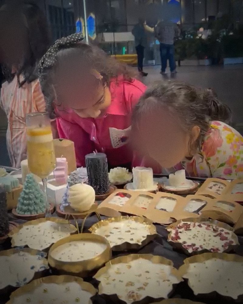 Children leaning in close to smell the candles